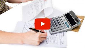 Person filling out forms and using a calculator