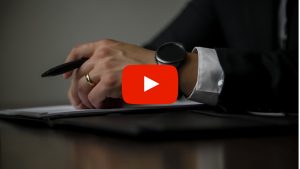 Person holding an ink pen and making notes