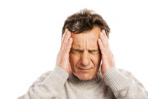 Person with headache rubbing head
