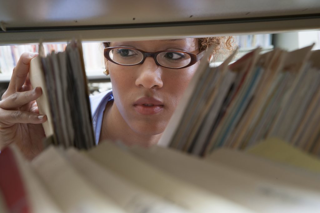 Person pulling medical records off of a shelf