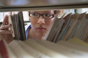 Person pulling medical records off of a shelf