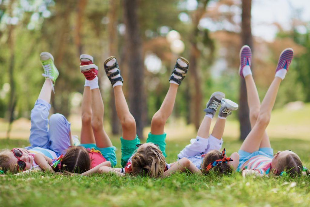 Kids laying in grass with legs in the air