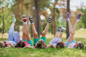 Kids laying in grass with legs in the air