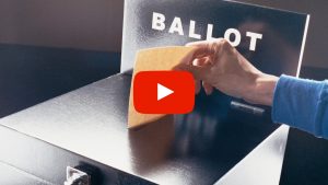 Person placing a ballot in a ballot box