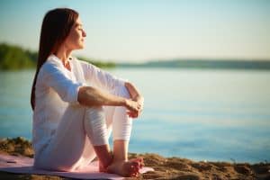 Person sitting at water's edge