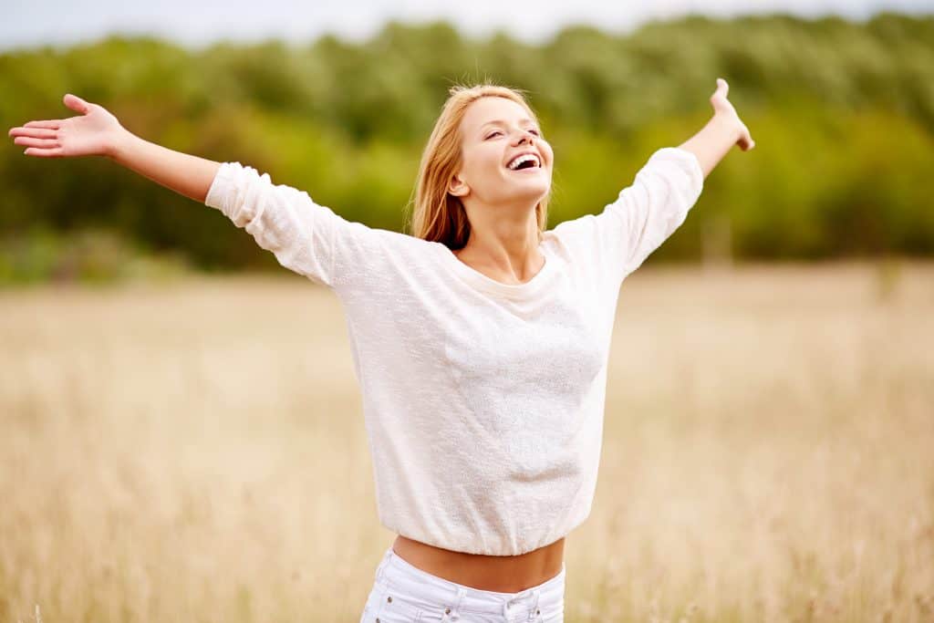Happy person standing with arms spread open