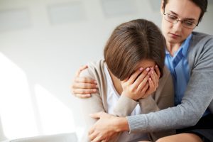 Image of person crying and receiving a hug