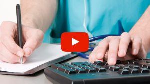 Person writting notes while typing