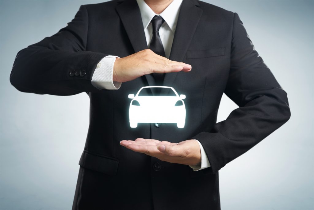 Person standing with image of car between hands