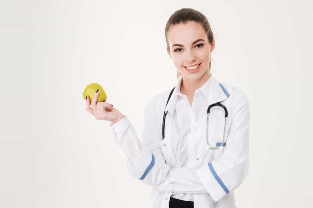 Doctor holding a piece of fruit