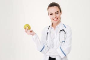 Doctor holding a piece of fruit