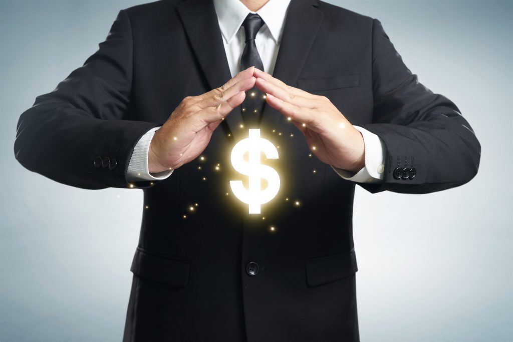Person standing with hands over a dollar sign