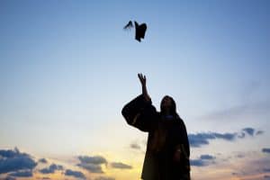 Graduate throwing hat in the air