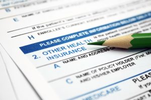 Insurance form with a greem pencil