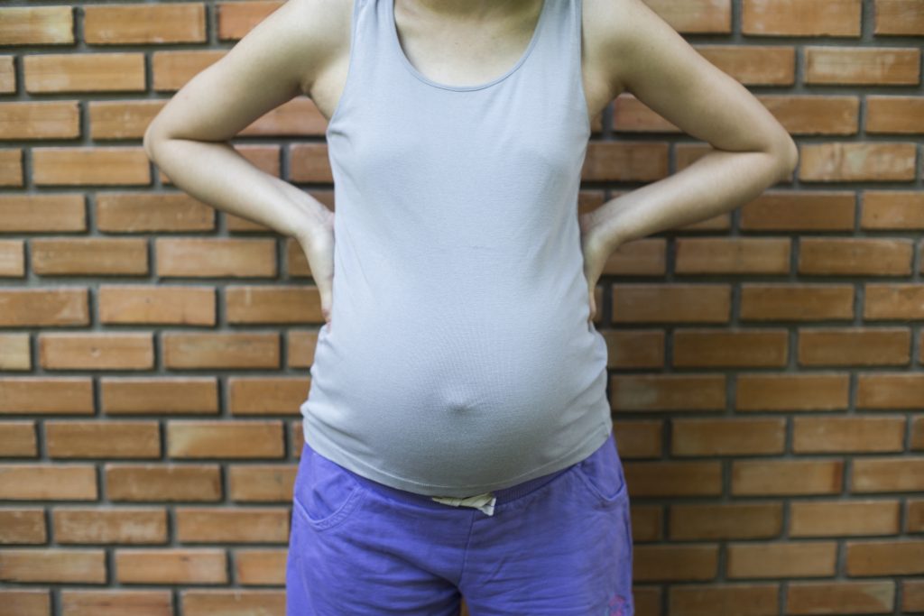 Pregnant person rubbing back