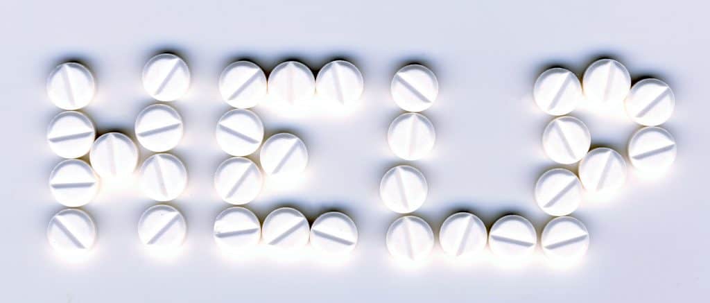 Pills layed out to spell "help"