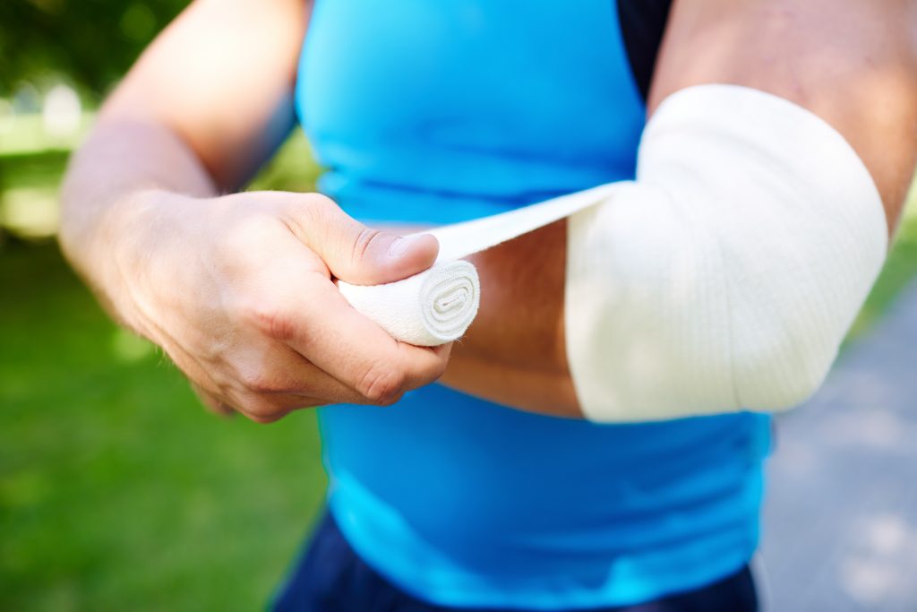 Person bandaging elbow