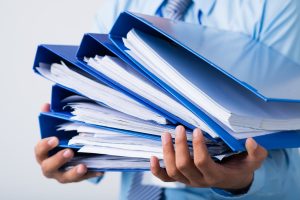 Person carying binders of documents