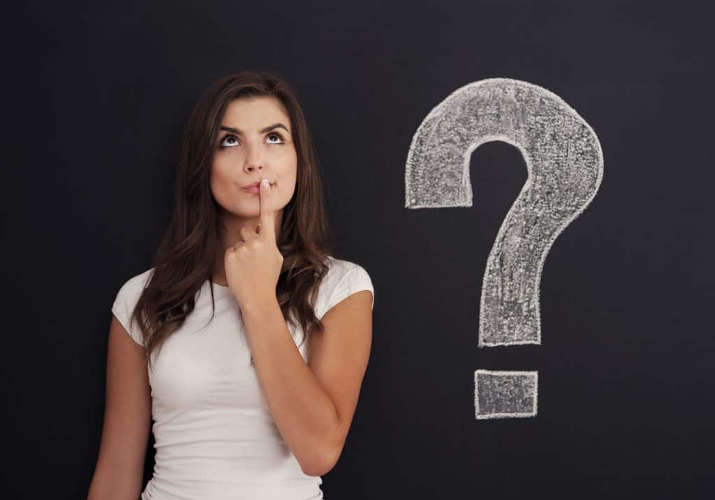 Person standing next to a question mark
