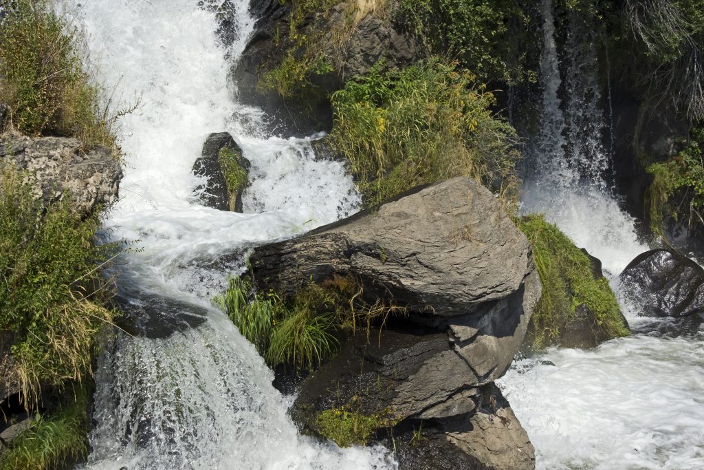 Image of water rushing past boulders