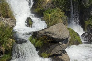 Image of water rushing past boulders