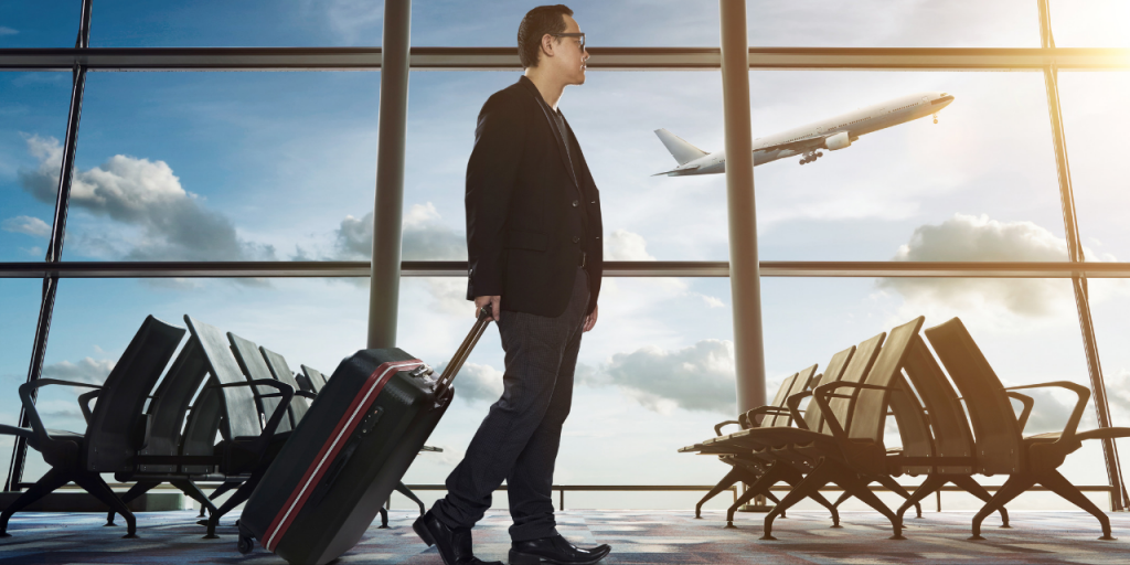 Person walking through airport carrying a suitcase