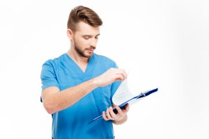 Doctor looking at papers on a clipboard