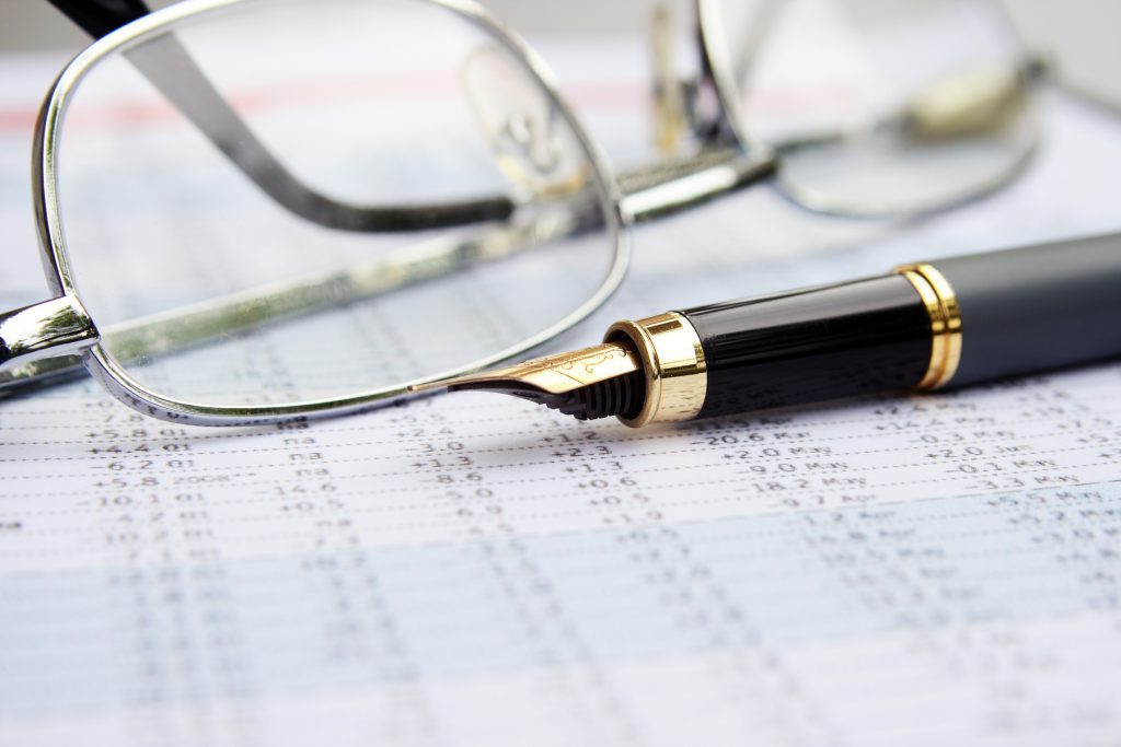 Ink pen laying on financial documents