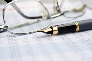 Ink pen laying on financial documents
