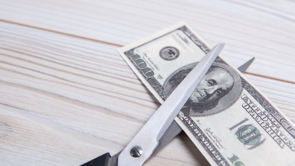 Scissors cutting a $100 bill