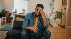 Person with headache rubbing head