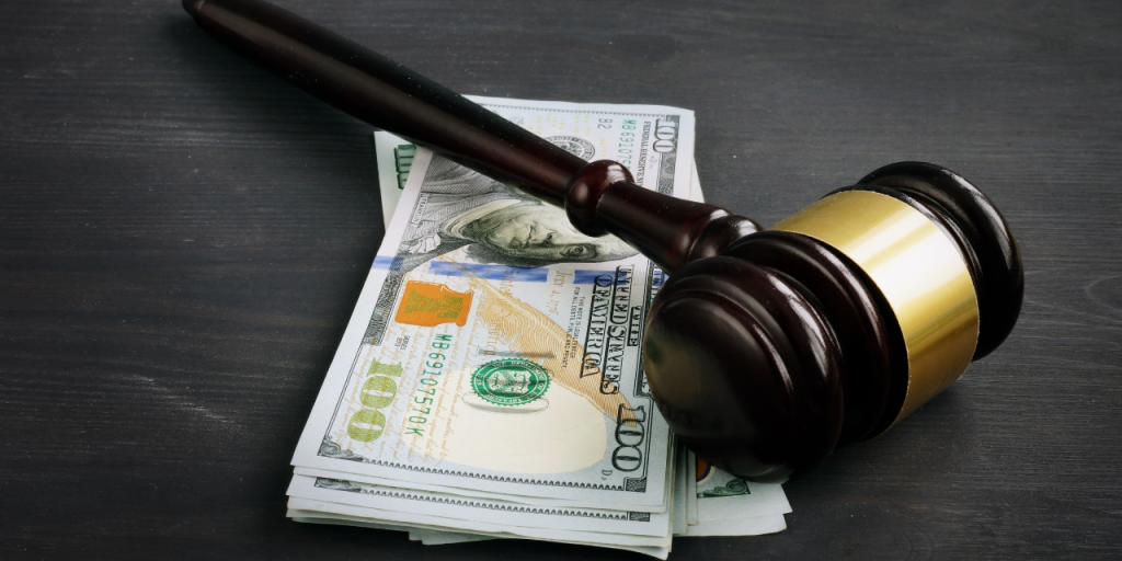 Gavel laying on a stack of money.