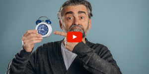 Person holding a clock and pointing to it